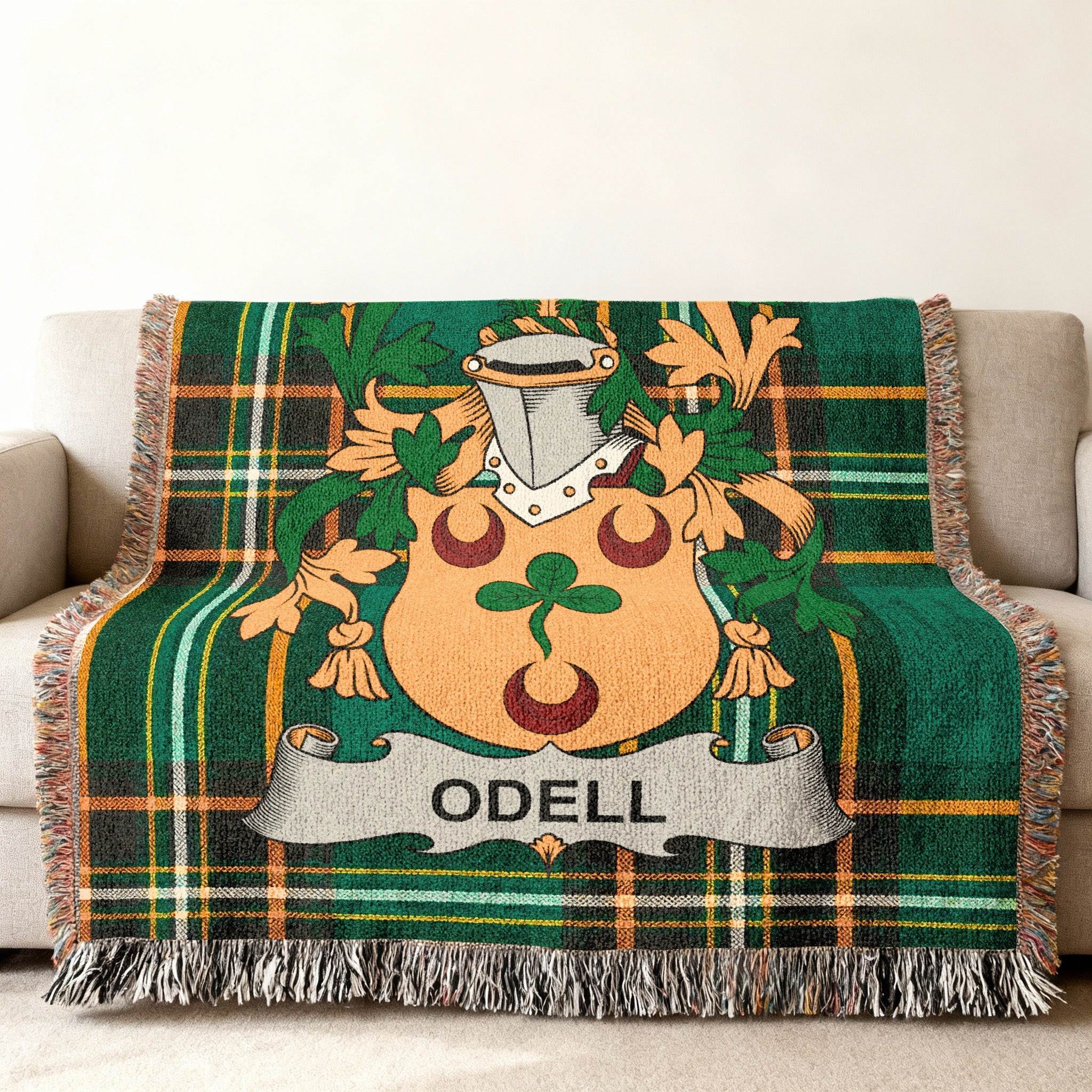 Green plaid throw blanket with Odell family crest at center.