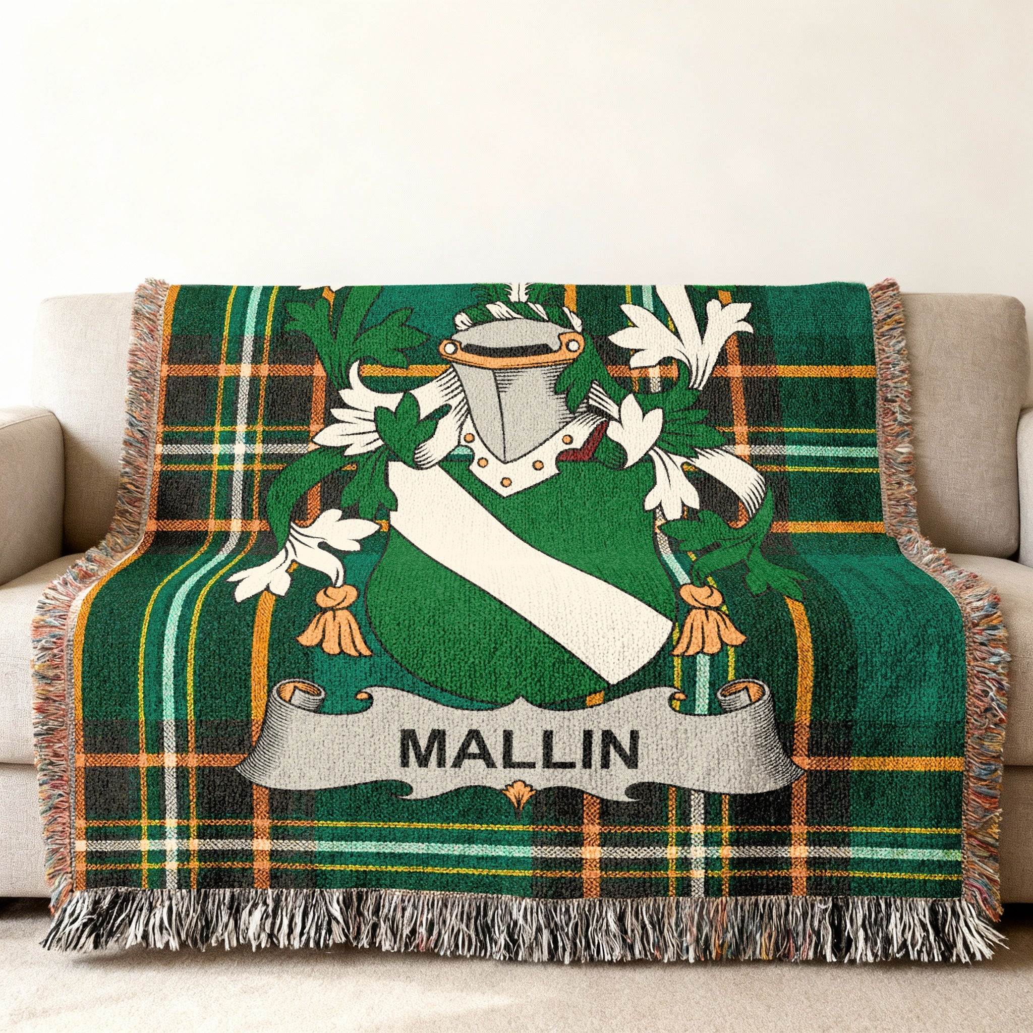 Green tartan throw blanket with the surname "MALLIN" on a crest.