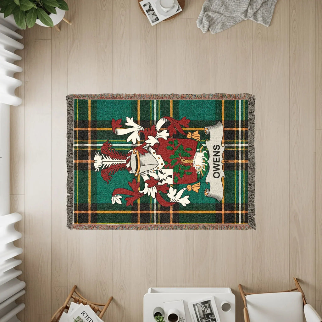 Owens family crest on a green tartan woven blanket with fringe.