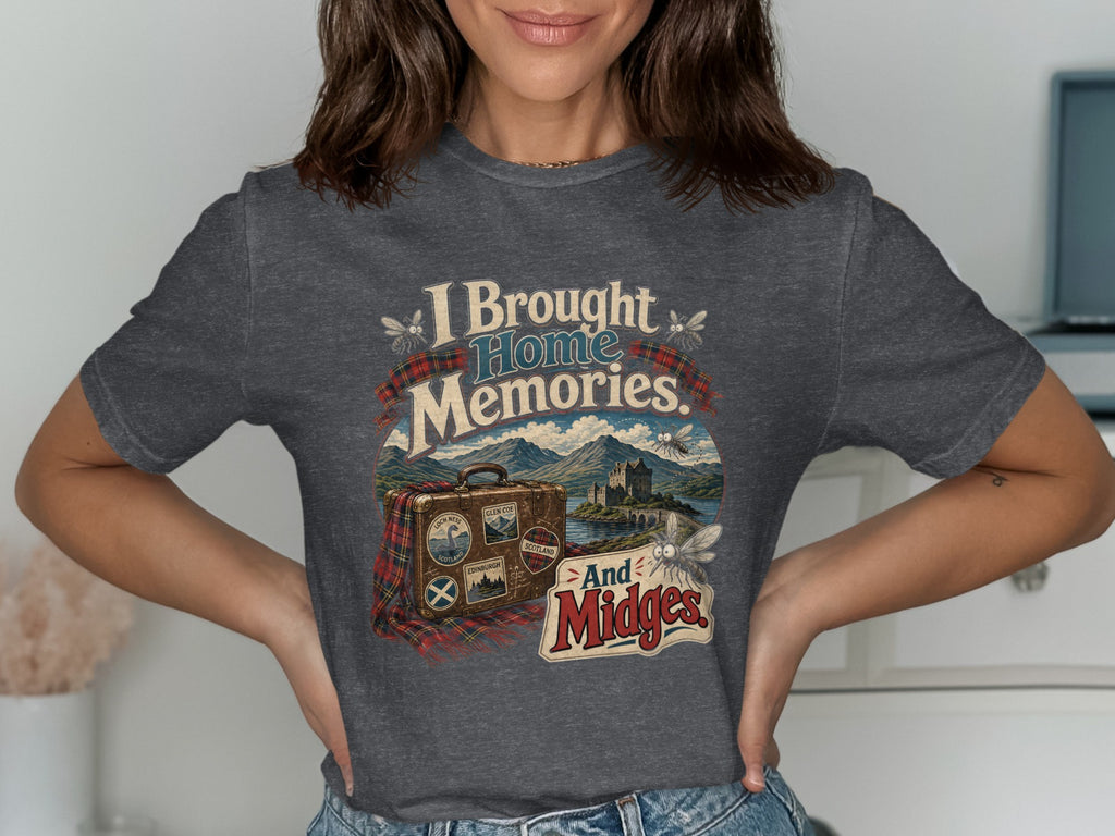 T-shirt graphic with text "I Brought Home Memories. And Midges." featuring a suitcase and Scottish landscape.