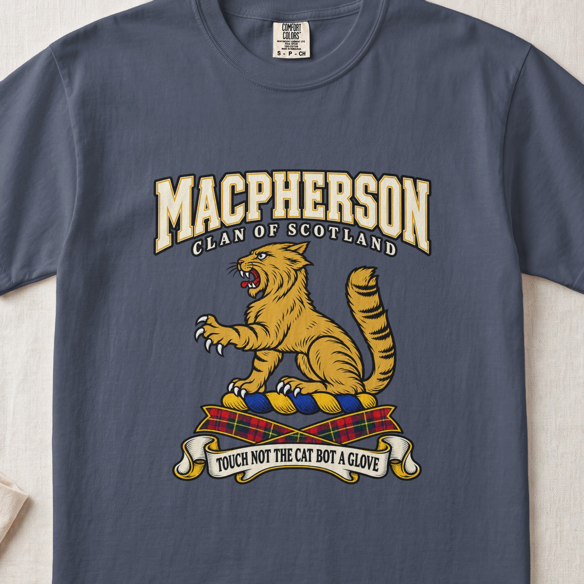 MacPherson graphic T-shirt in Midnight blue, front flat lay showing varsity lettering and seated gold wildcat with black stripes, raised paw and upright tail.