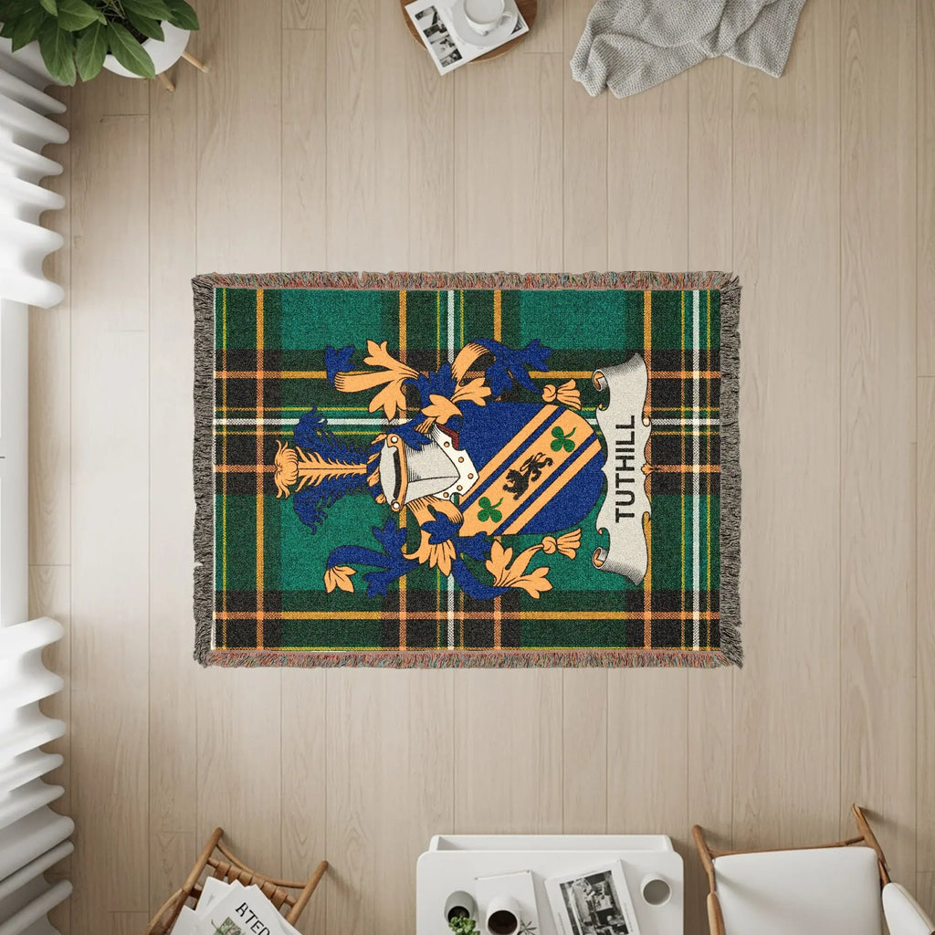 Woven blanket with TUTHILL crest in green and blue tartan pattern.