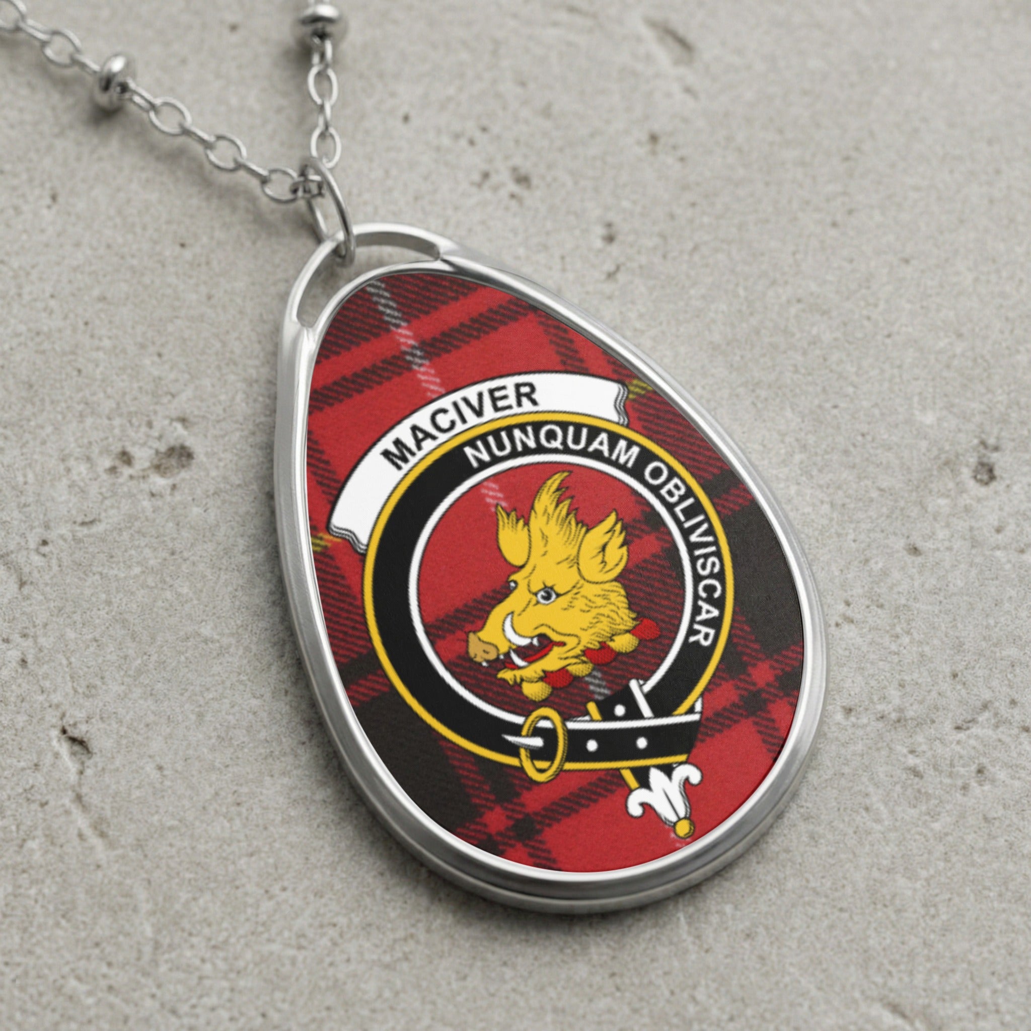 MacIver clan crest necklace with boar on red tartan background.