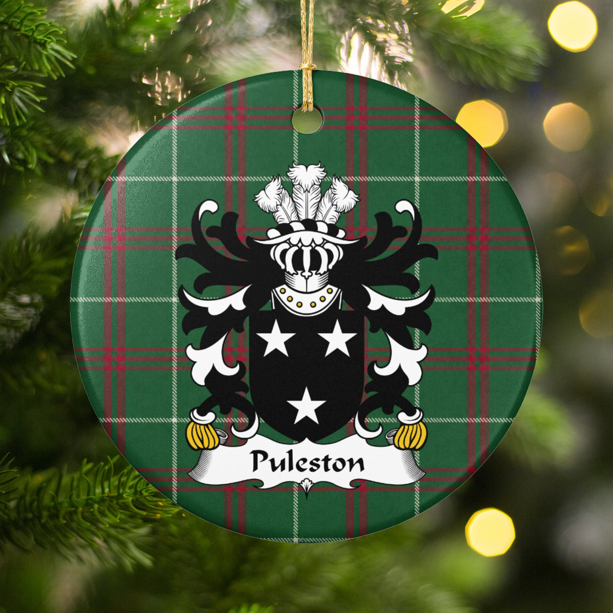 Puleston round Welsh National Tartan ornament hanging on a Christmas tree with warm lights, featuring three white stars on a black shield.