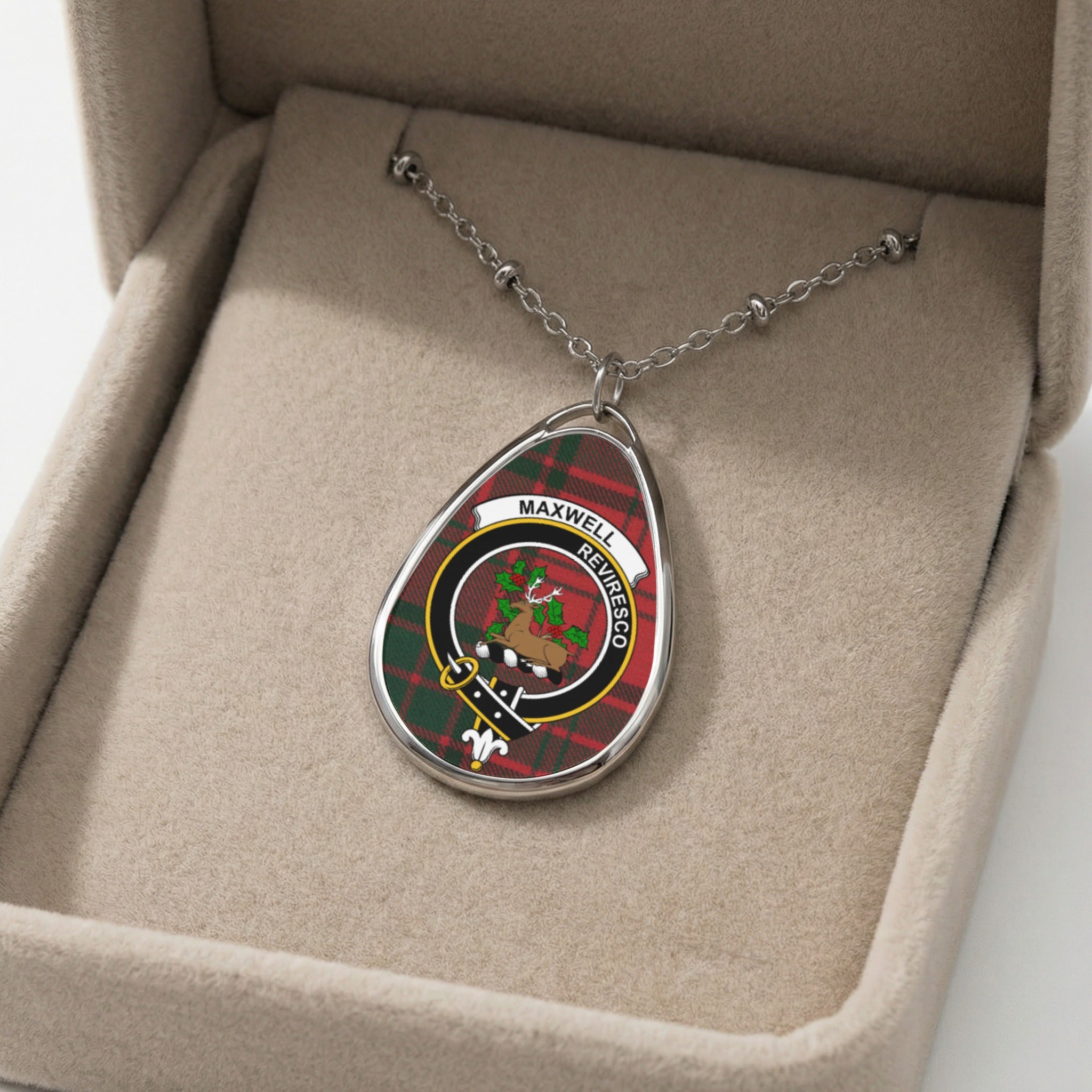 Silver necklace with Maxwell clan crest on tartan inside a jewelry box.