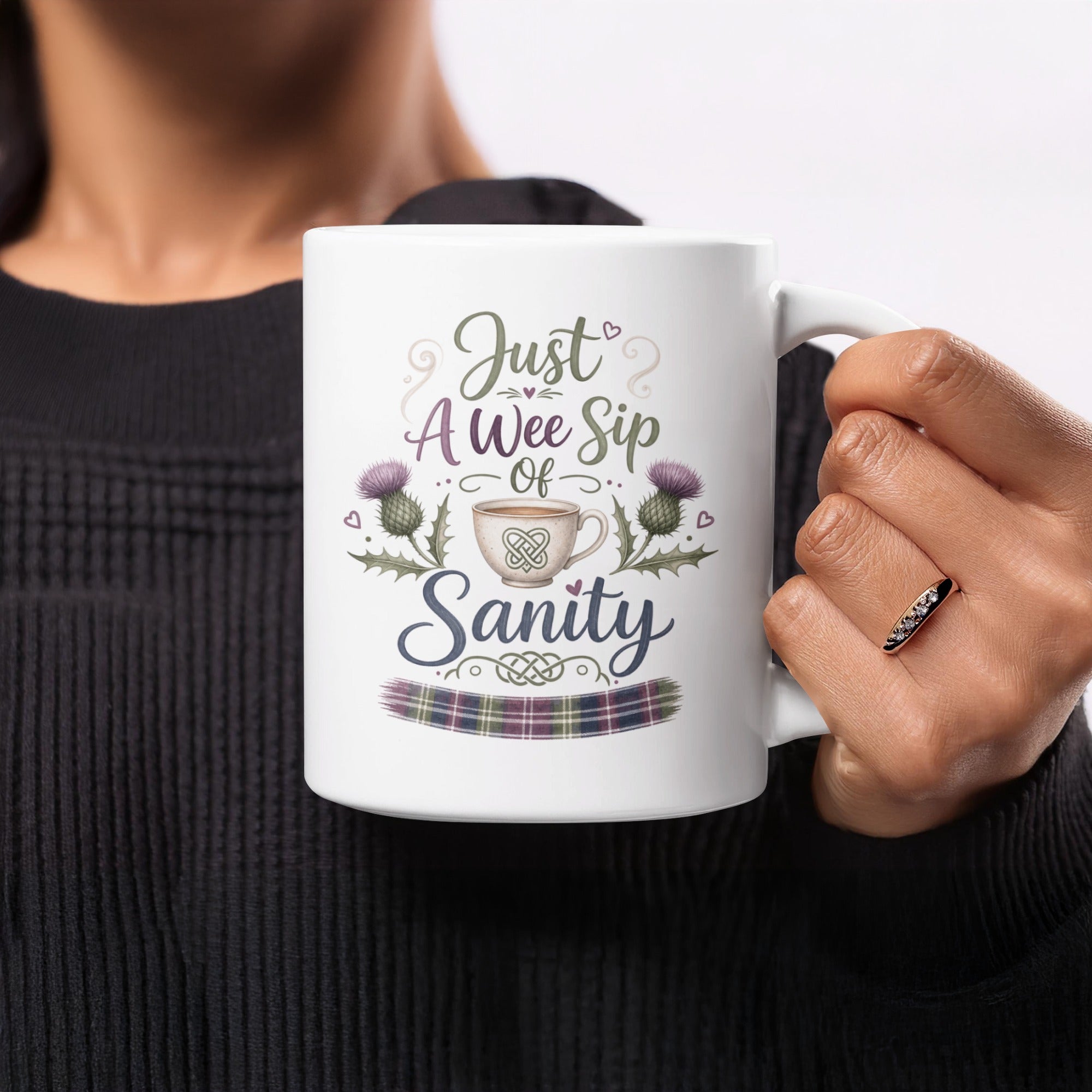 White mug with "Just A Wee Sip of Sanity" text and tartan pattern.