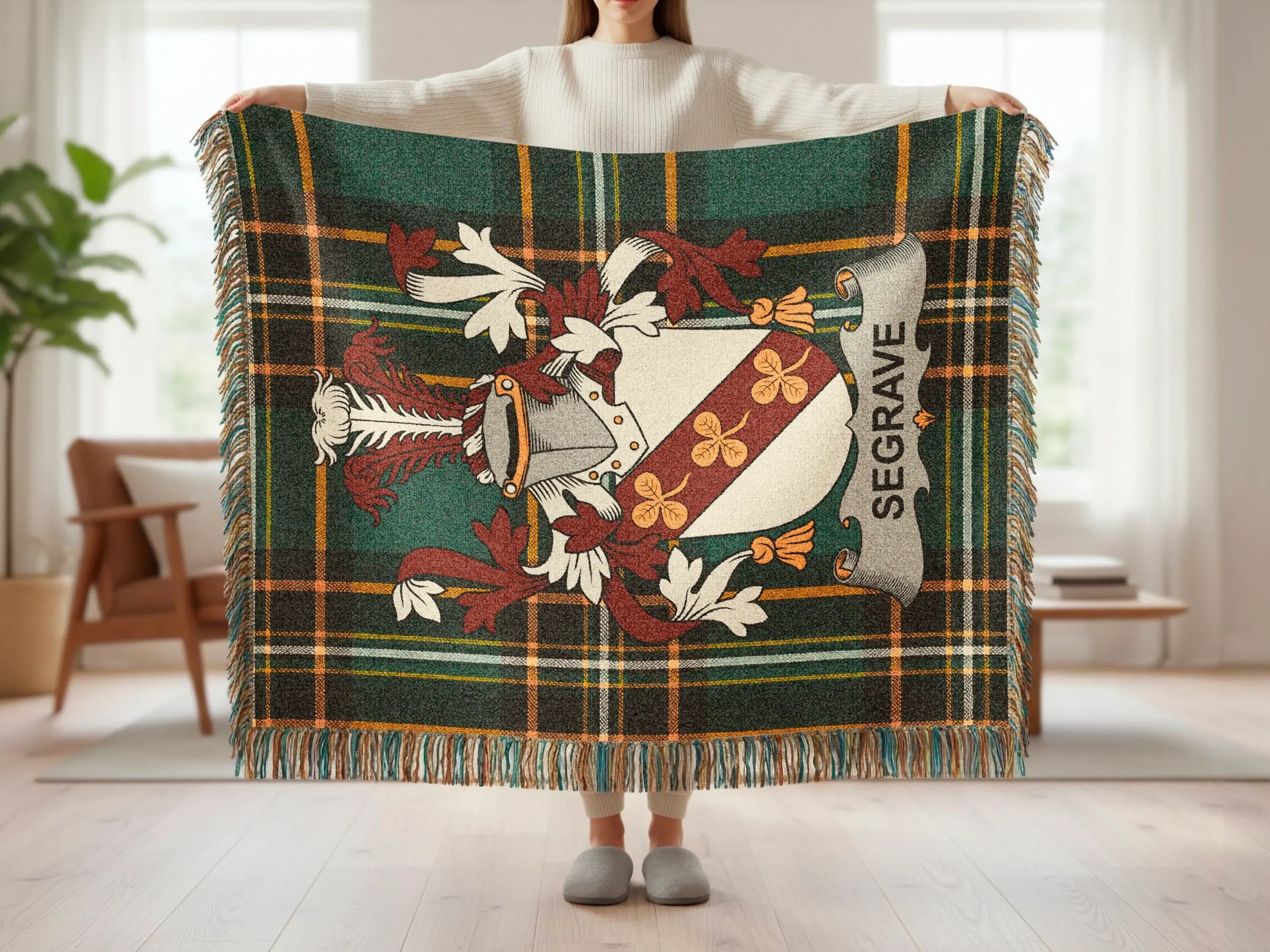 Seagrave tartan blanket with coat of arms displayed by a person.