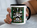 White mug with black handle featuring Wickliffe family crest on tartan background.