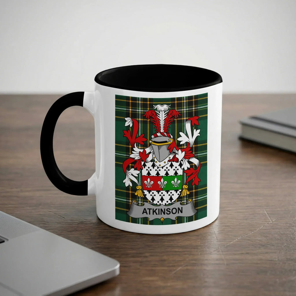 White mug with black handle displaying Atkinson family crest with green, red, and white checkered background.