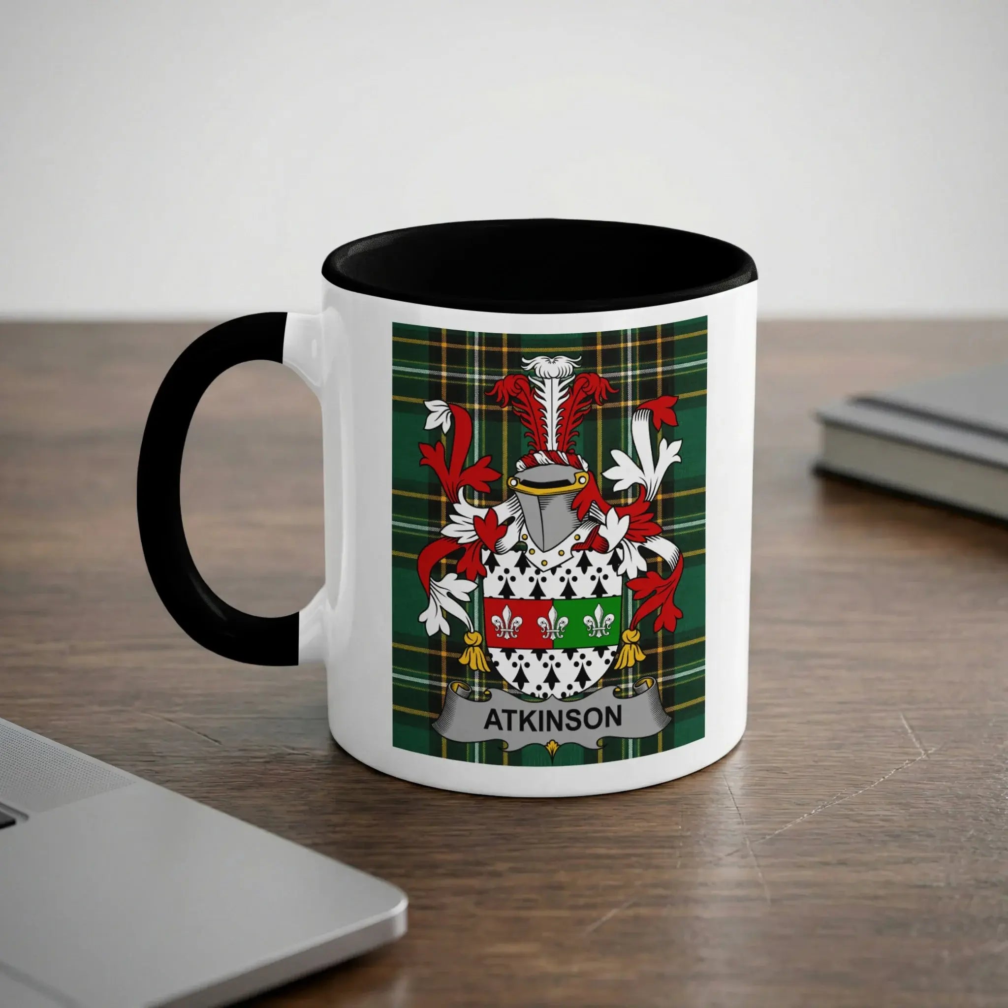 White mug with black handle displaying Atkinson family crest with green, red, and white checkered background.