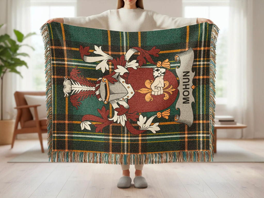 Green tartan throw blanket with a crest featuring a shield and text "MOHUN".