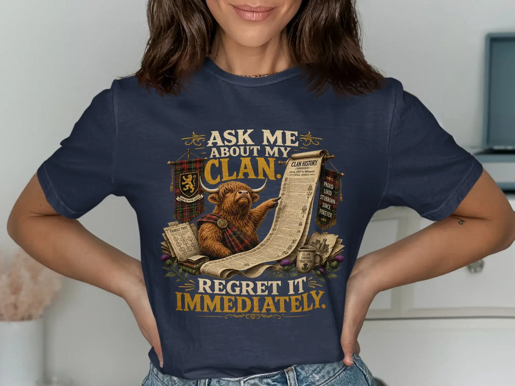 T-shirt with Scottish Highland cow reading clan history, text about clan pride.