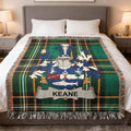 Tartan blanket with Keane family crest centered on a bed.