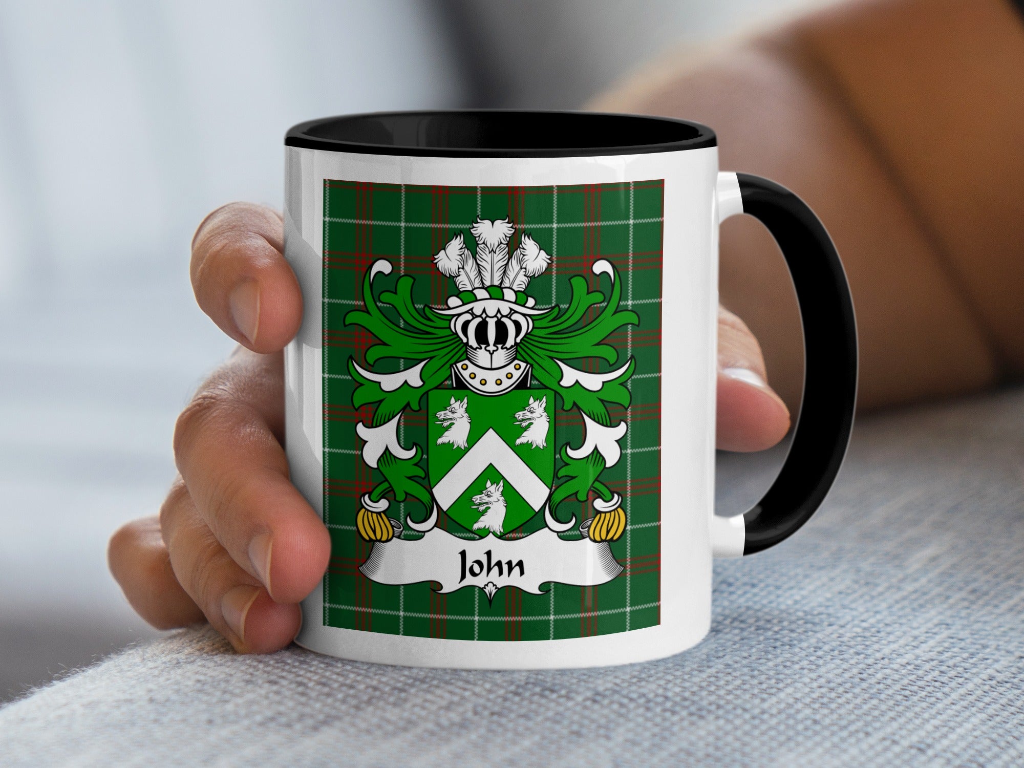 White mug with black handle displaying a green tartan and the John coat of arms.