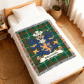 Green tartan blanket with Meredith family crest draped on a bed.