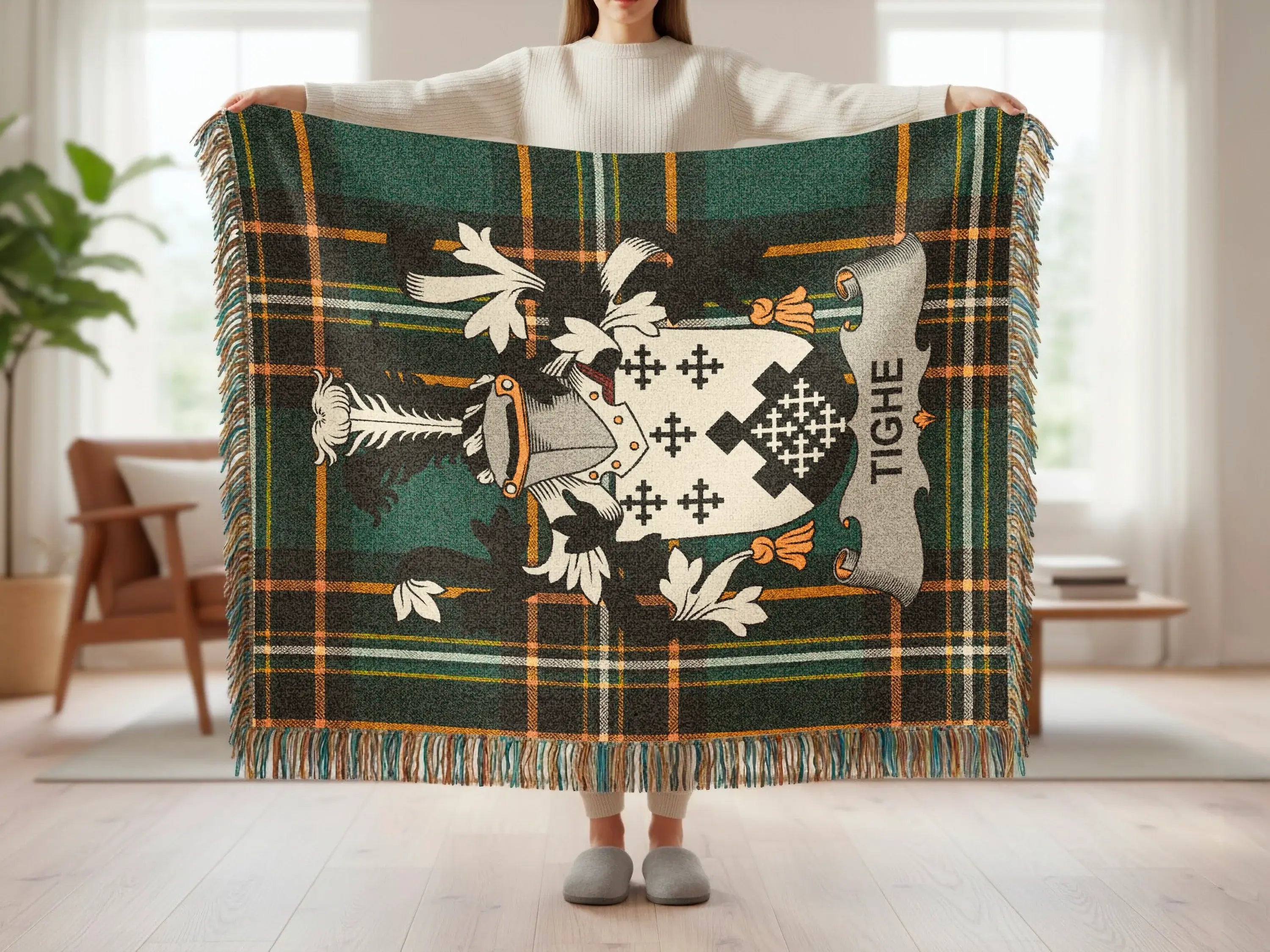 Tighe family crest on a dark green tartan wool blanket with fringe.