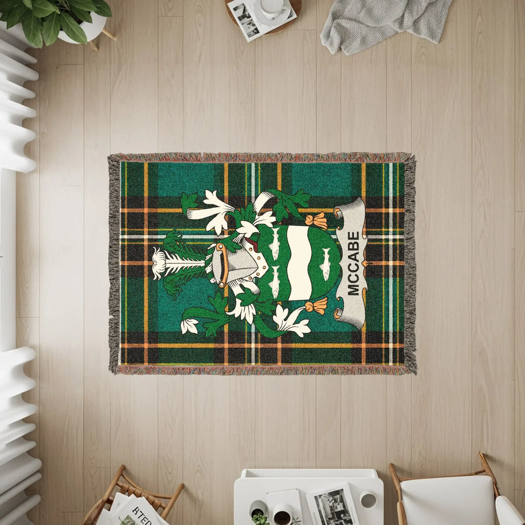 McCabe tartan blanket with coat of arms displayed on a wooden floor.