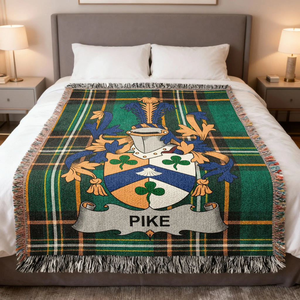 Tartan throw blanket featuring the Pike family crest on a bed.
