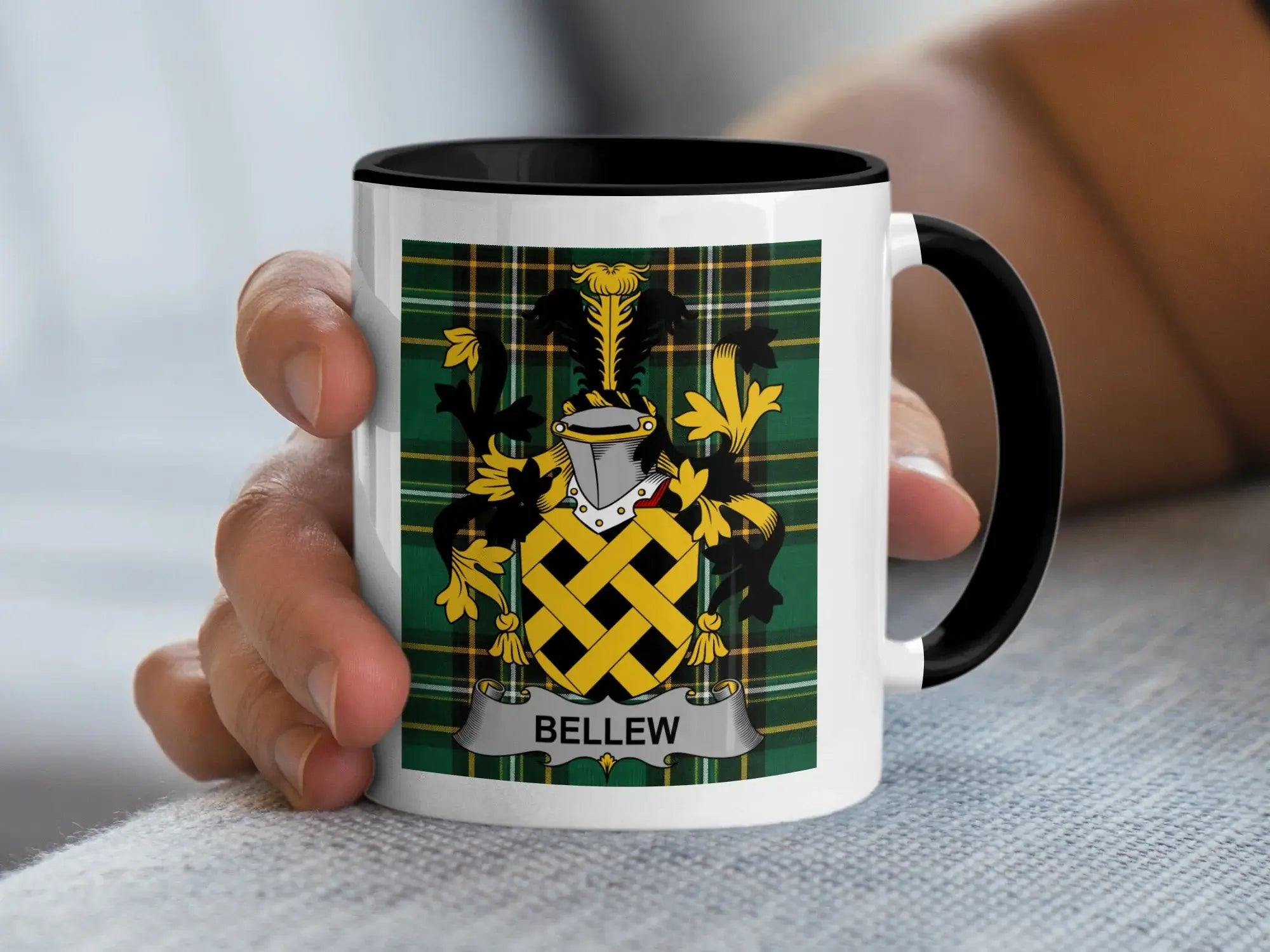 White mug with black rim and handle, featuring the BELLEW family crest on plaid.