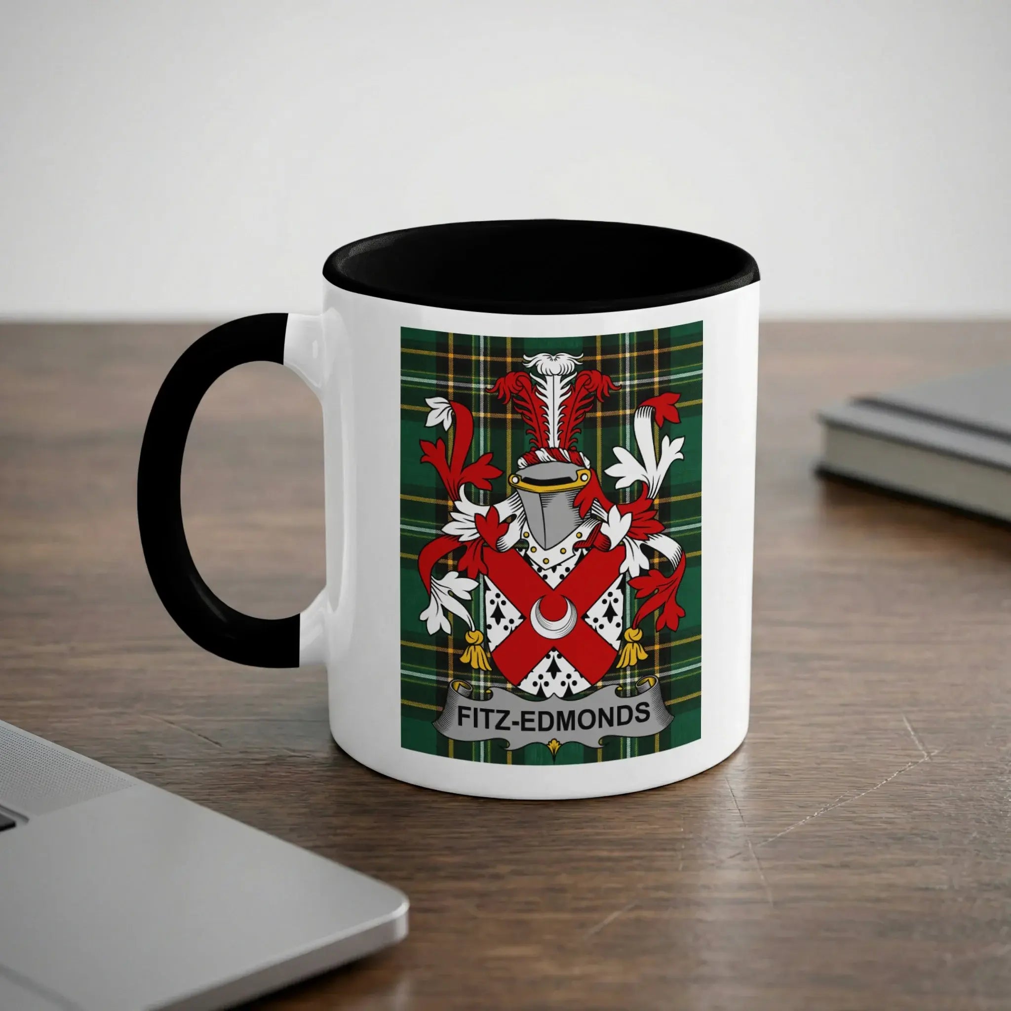 White mug with black rim displaying Fitz-Edmonds coat of arms on a wooden desk.