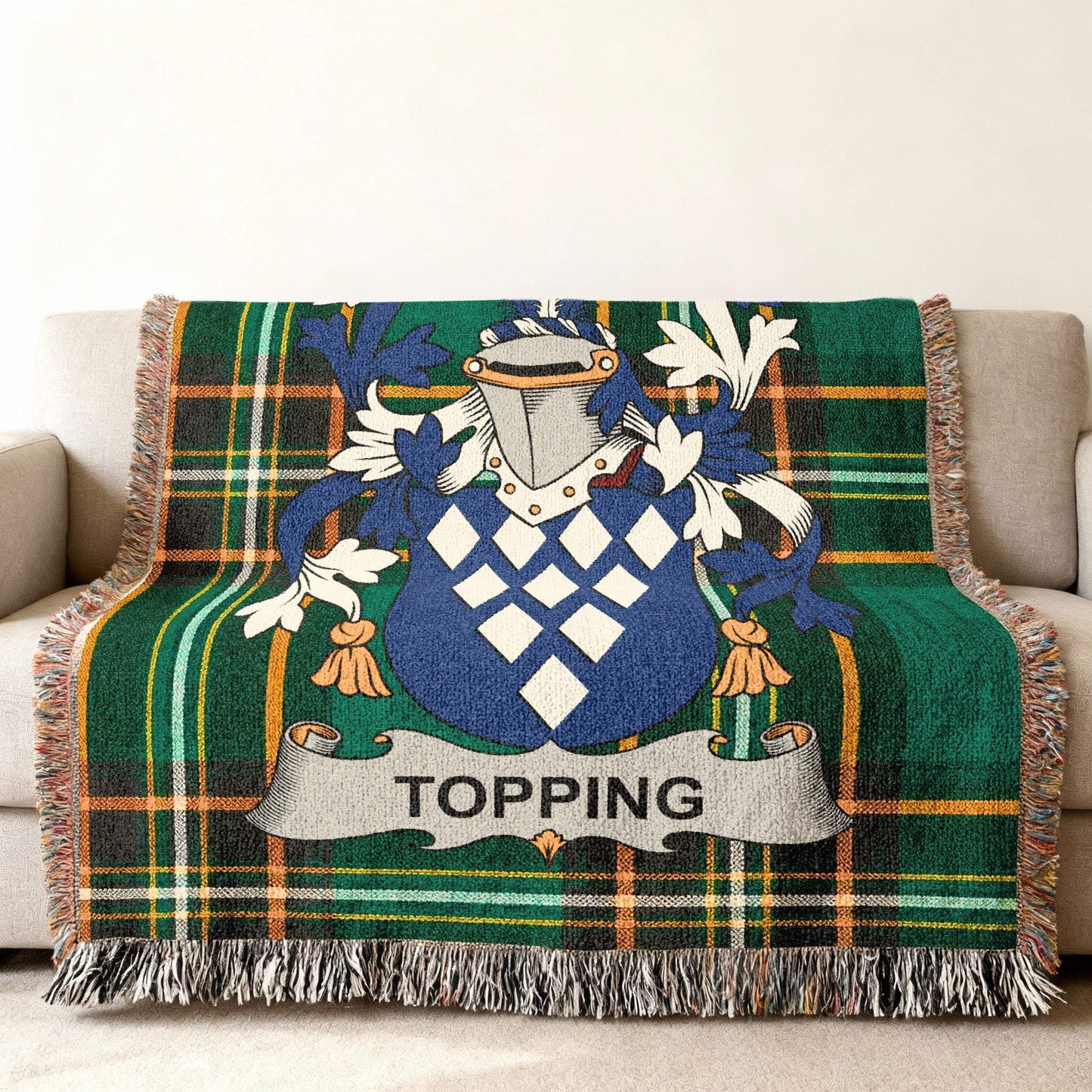 Topping family crest on a green tartan plaid throw blanket with tassels.