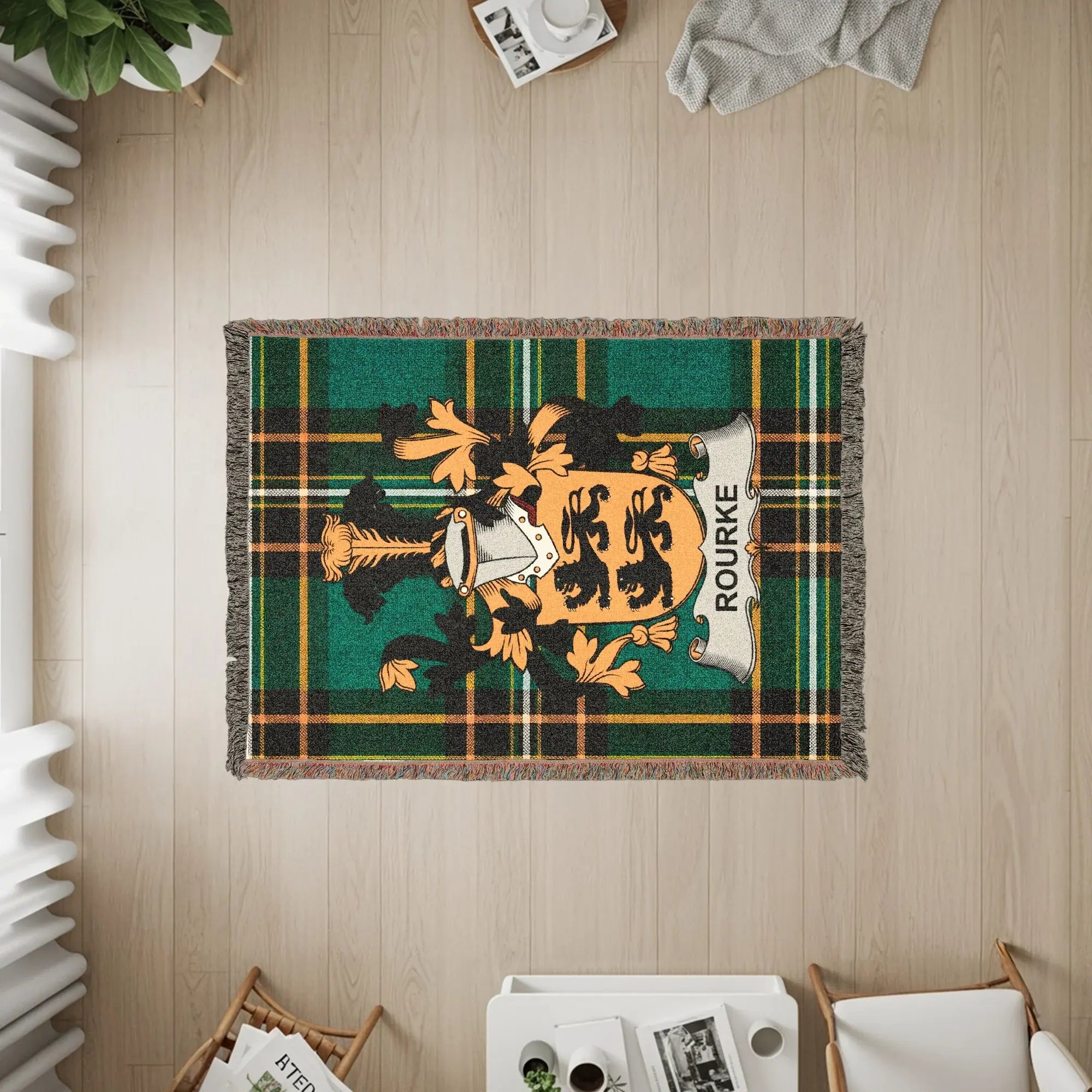 Woven blanket with Rourke family crest on green tartan background.