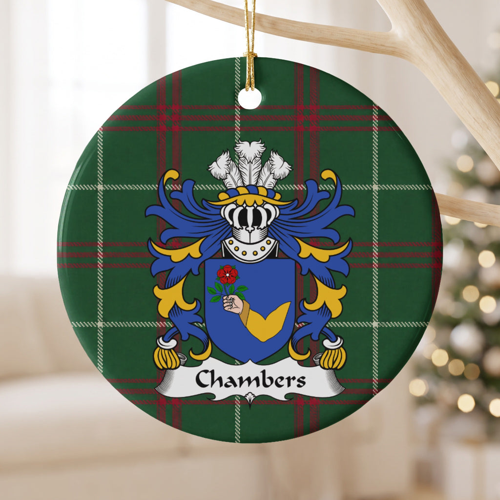 Chambers ornament hanging from a pale wooden branch; a hand in a gold sleeve holding a red rose on a blue shield on Welsh national tartan.