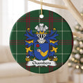 Chambers ornament hanging from a pale wooden branch; a hand in a gold sleeve holding a red rose on a blue shield on Welsh national tartan.
