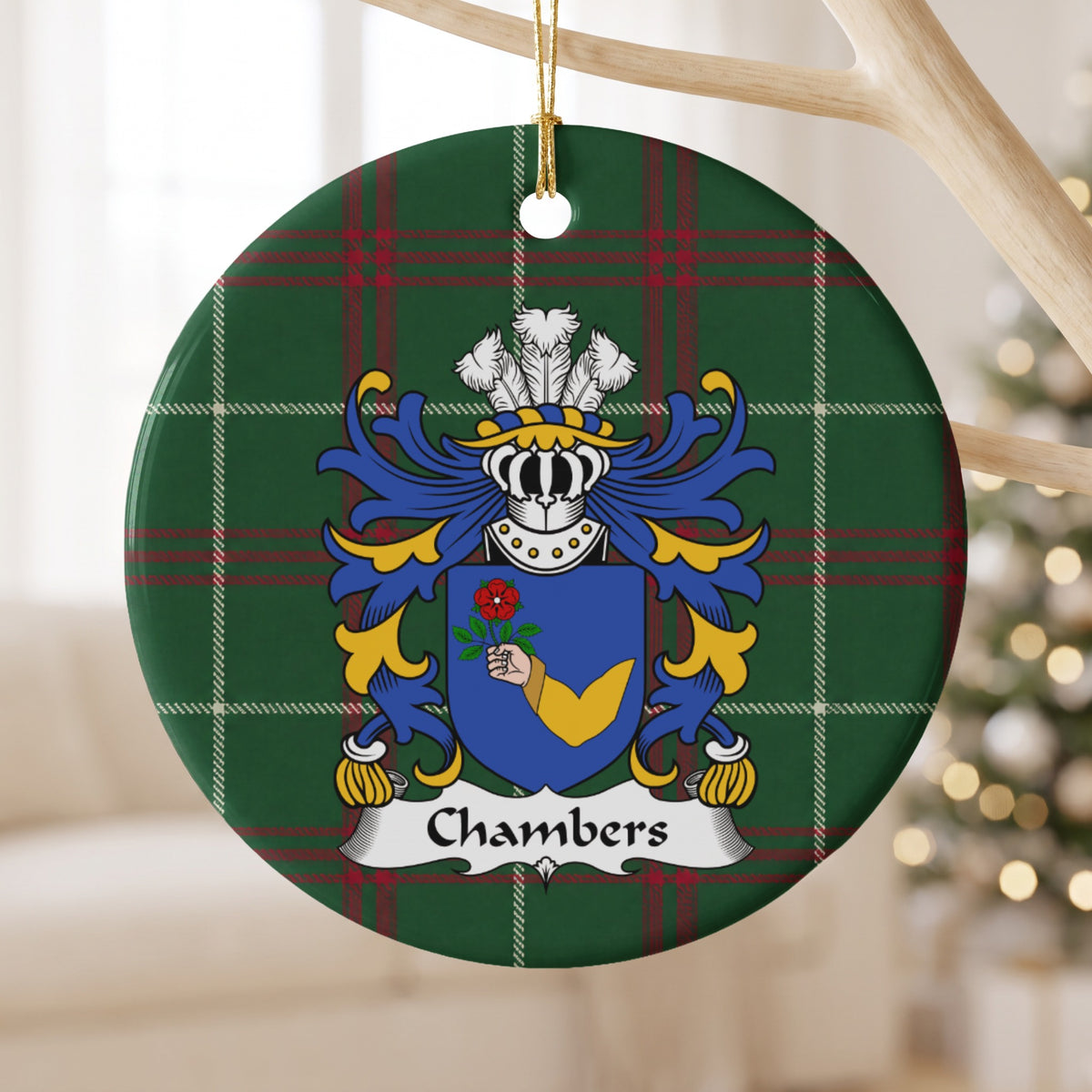 Chambers ornament hanging from a pale wooden branch; a hand in a gold sleeve holding a red rose on a blue shield on Welsh national tartan.