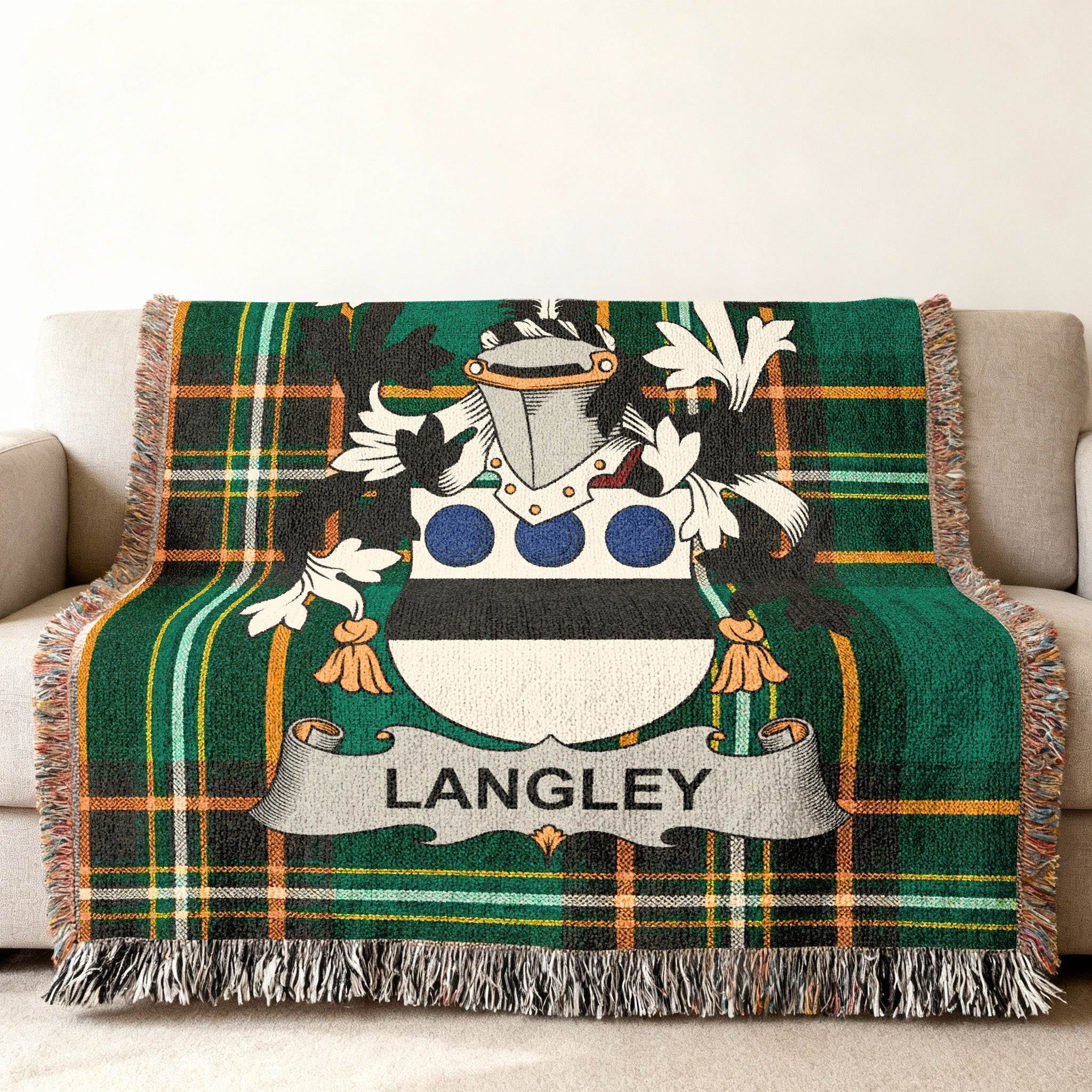 Green plaid throw blanket with Langley family crest centered on it.