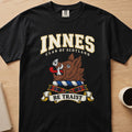 Innes clan crest with brown boar head on a black Comfort Colors T-shirt, front view
