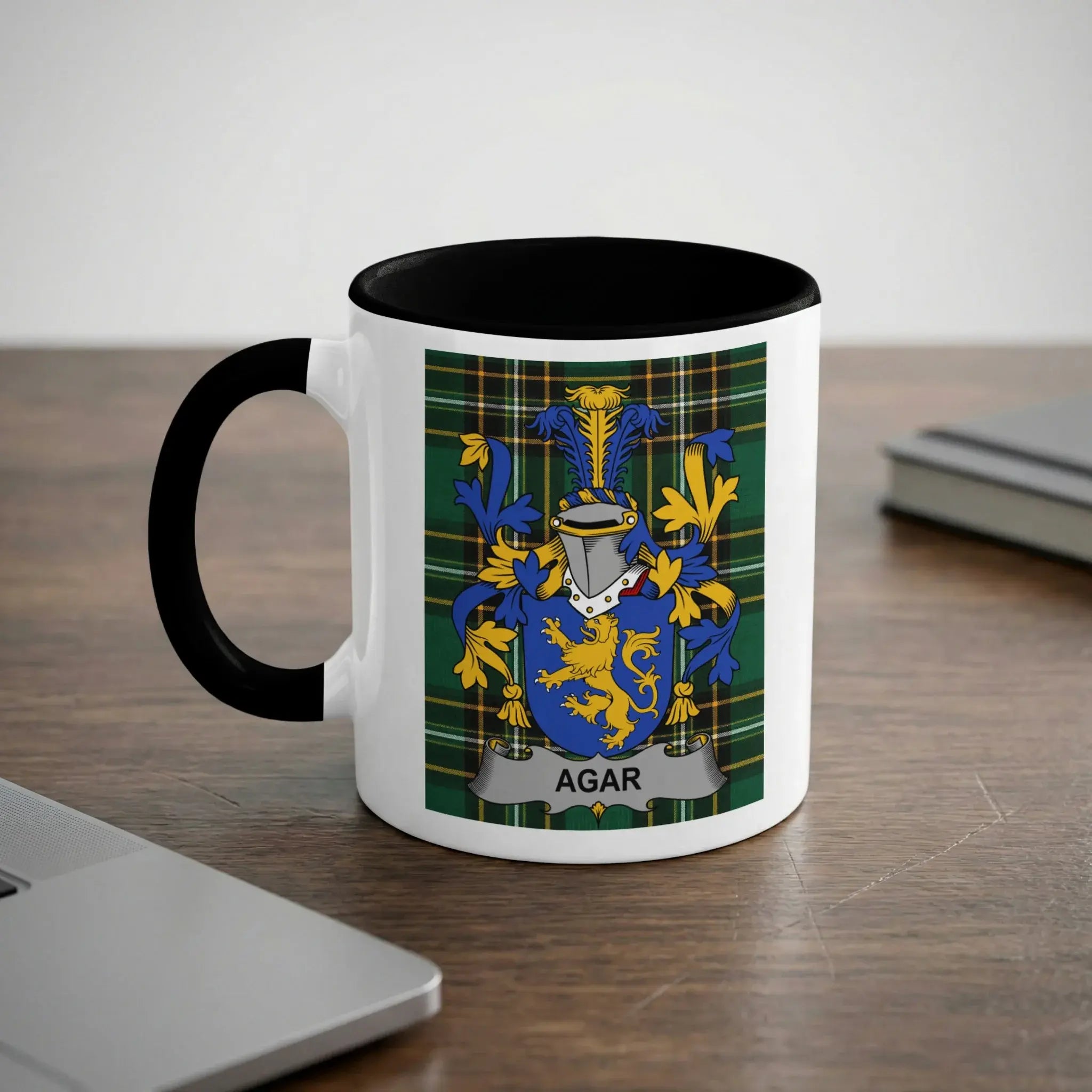 White mug with black interior featuring the Agar family crest on a green tartan background.