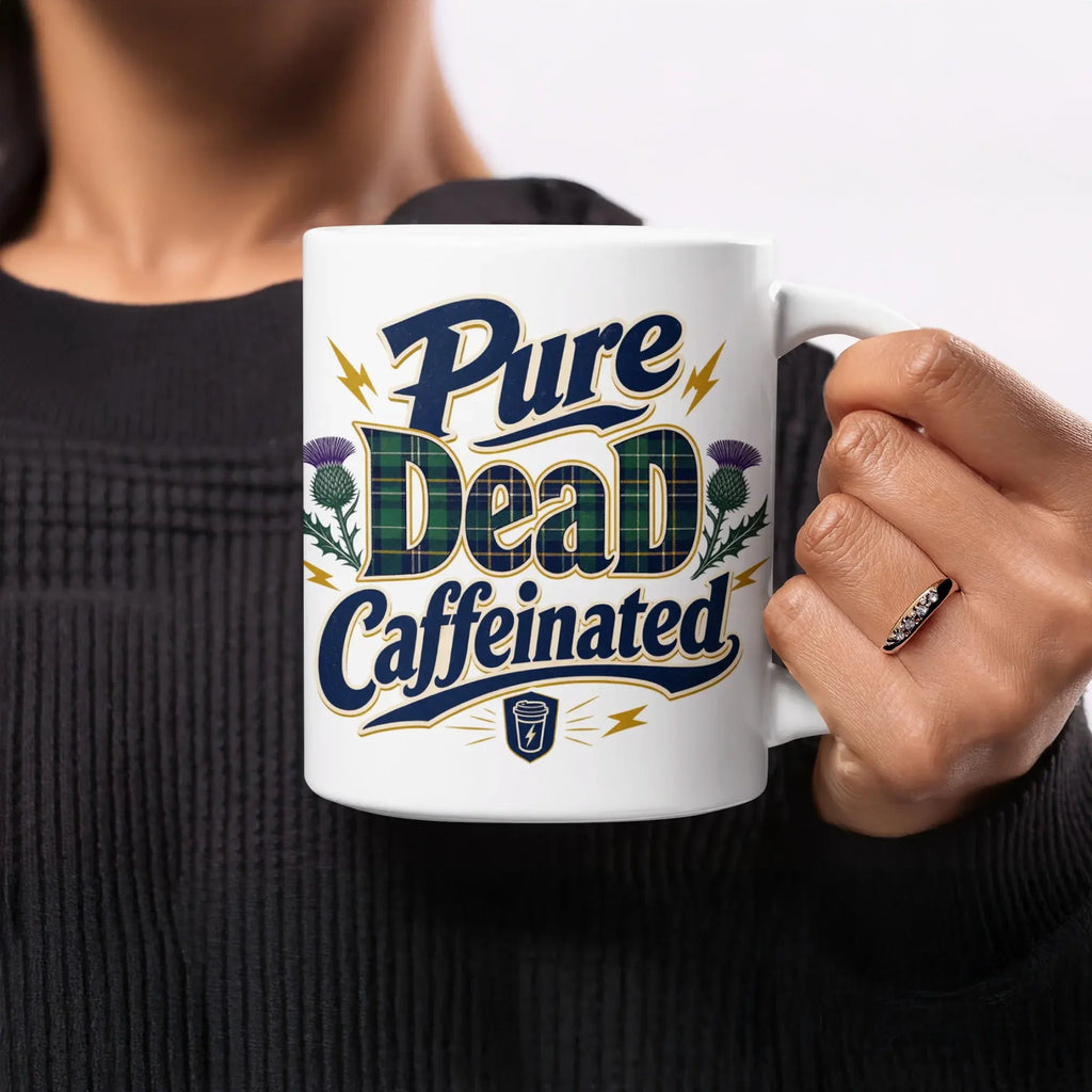White mug with "Pure Dead Caffeinated" text and thistle graphics.