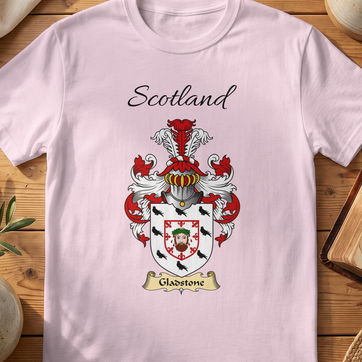 Light Pink Gladstone Scottish family shield T-shirt featuring a central face motif framed by a red border