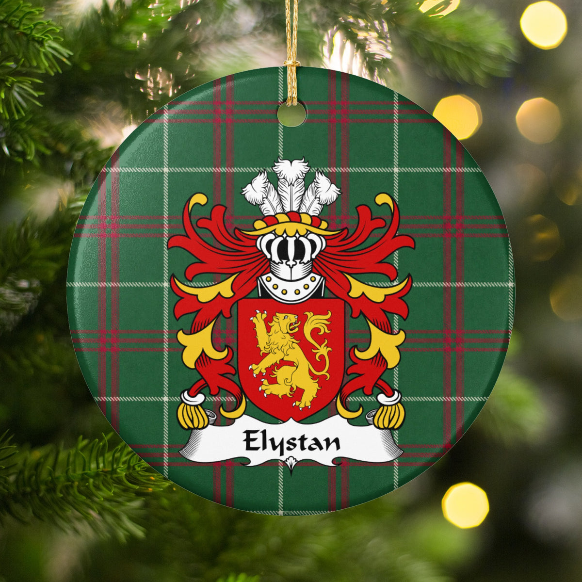 Elystan ornament hanging among Christmas tree branches and warm lights; a gold lion on a red shield on Welsh national tartan.