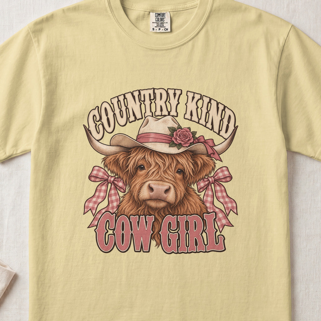 Country Kind Cow Girl Highland cow design on a Butter Comfort Colors 1717 T-shirt, flat lay