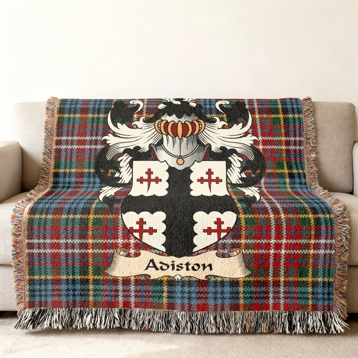 Adiston Scottish family shield woven blanket with Caledonia tartan background on a sofa