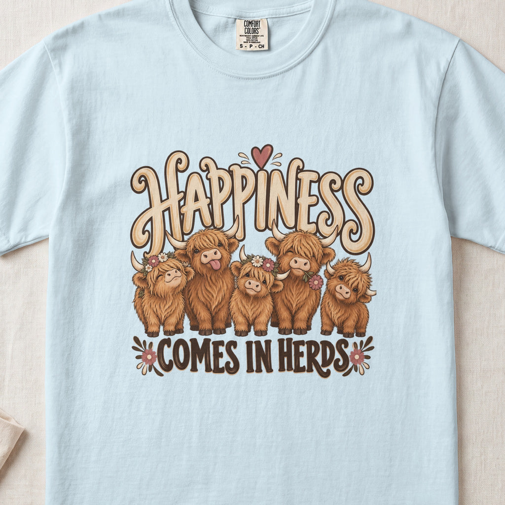 Happiness Comes in Herds Highland cow design on a Chambray Comfort Colors 1717 T-shirt, flat lay