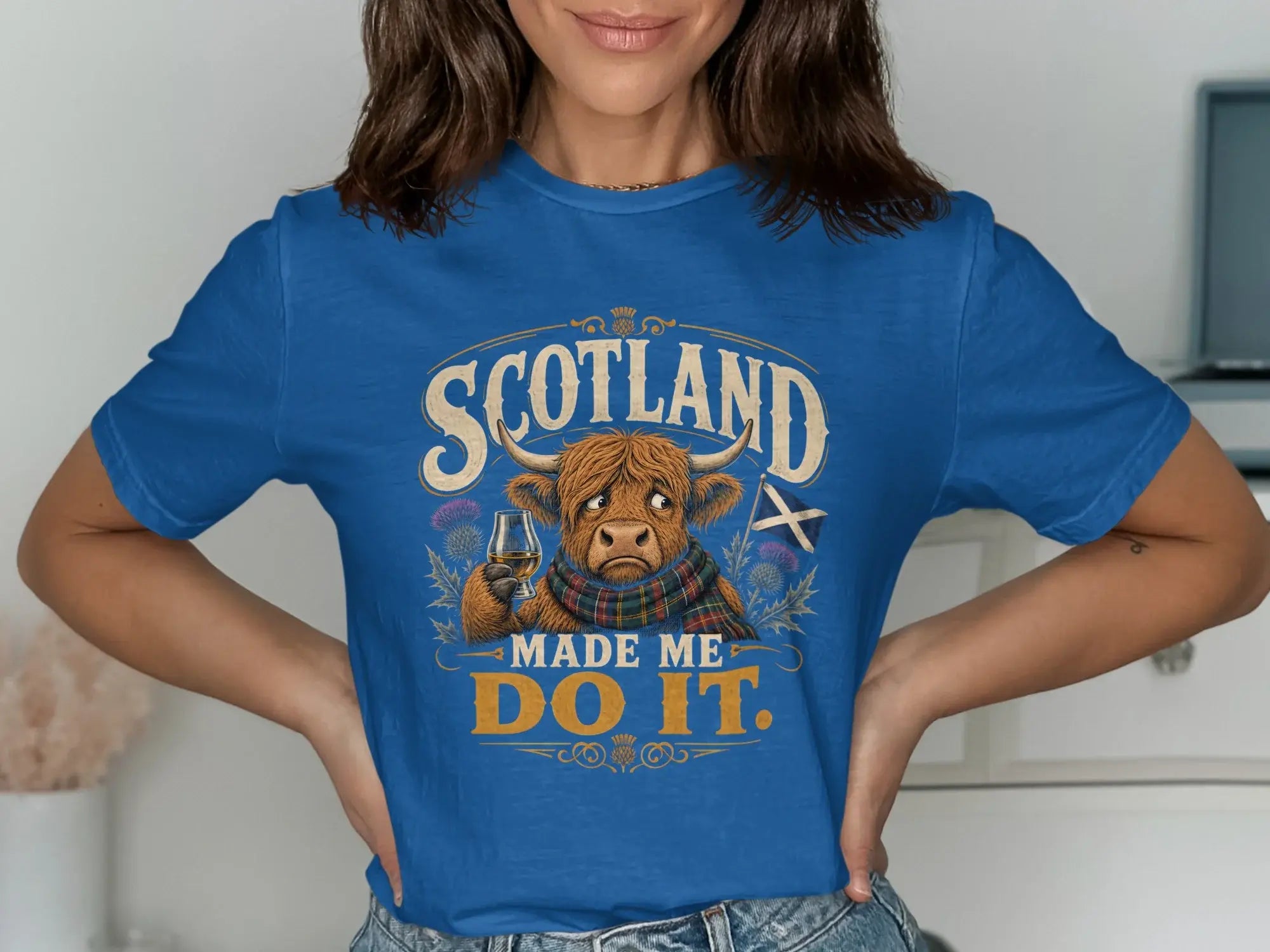 Blue t-shirt with Scottish highland cow and text "Scotland Made Me Do It."