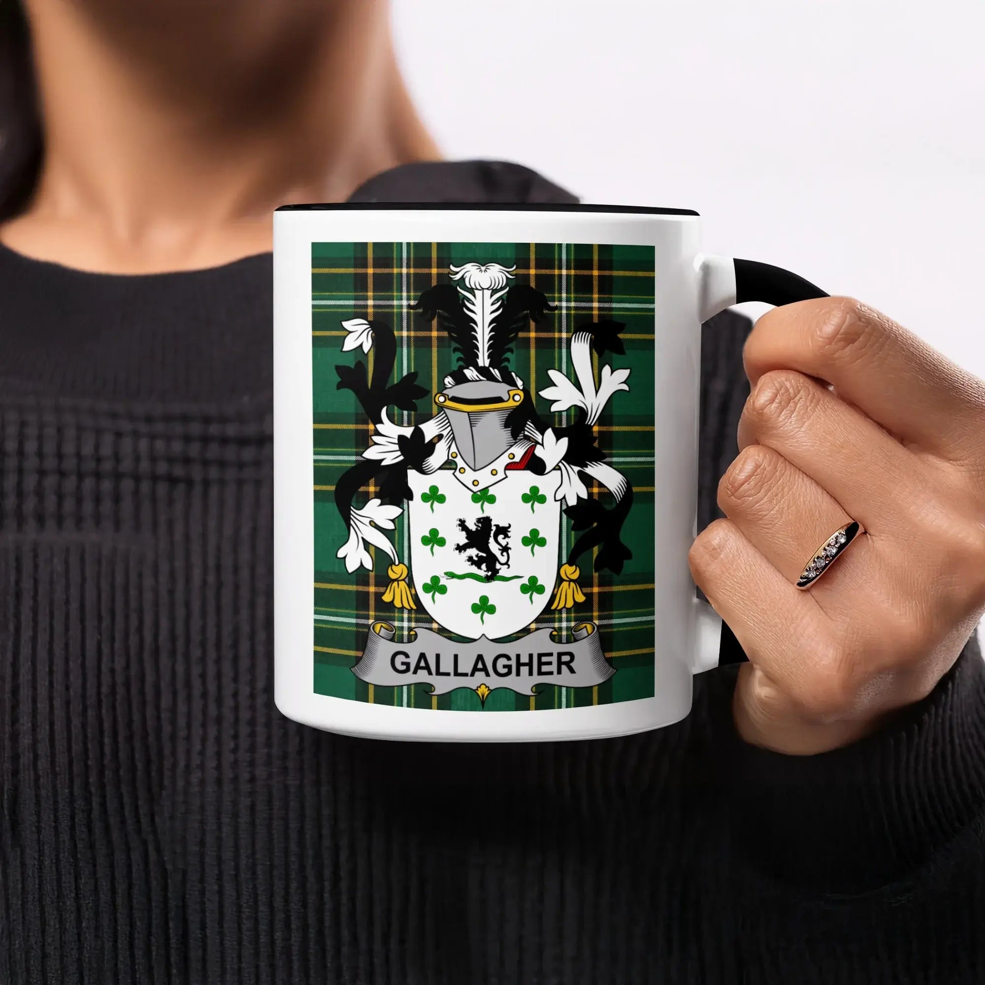 Black mug with Gallagher family crest on green plaid background.