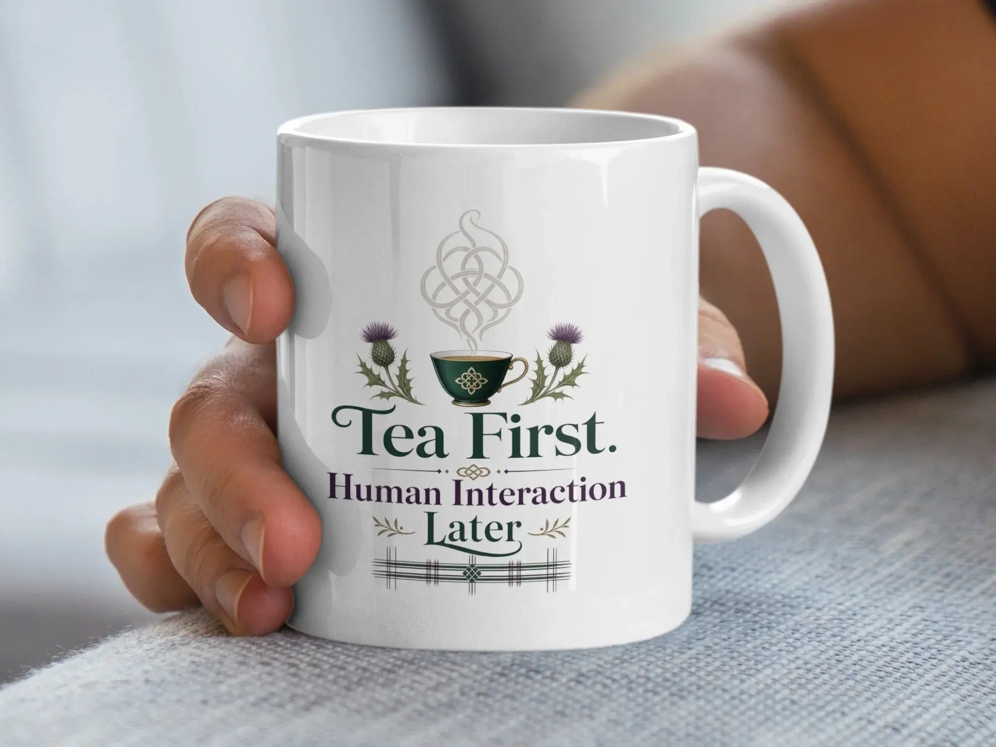 White mug with "Tea First. Human Interaction Later" and Celtic knot thistle design.