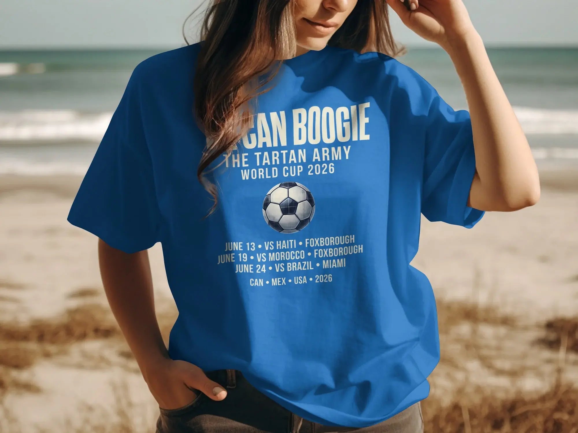 Blue t-shirt with "CAN BOOGIE THE TARTAN ARMY WORLD CUP 2026" and match schedule.