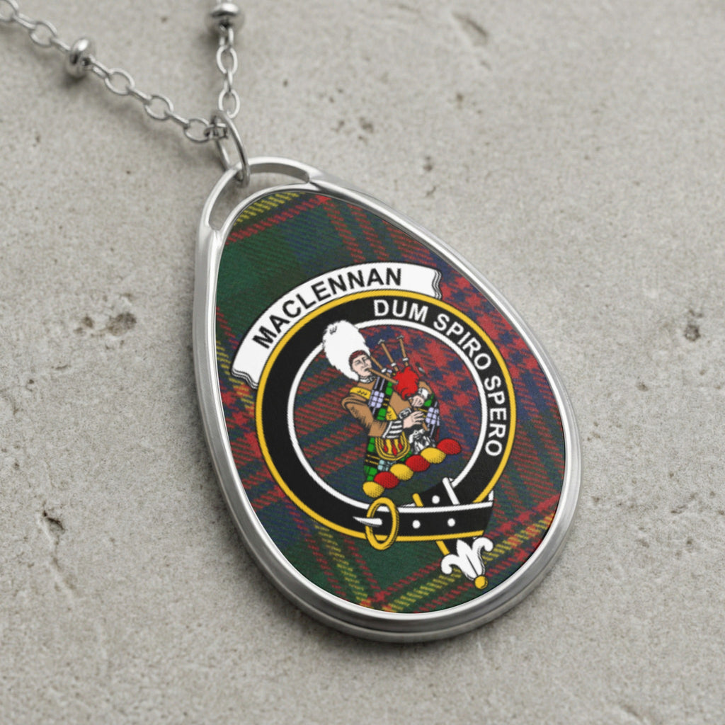 Pendant with MacLennan clan crest and tartan, against a gray textured surface.