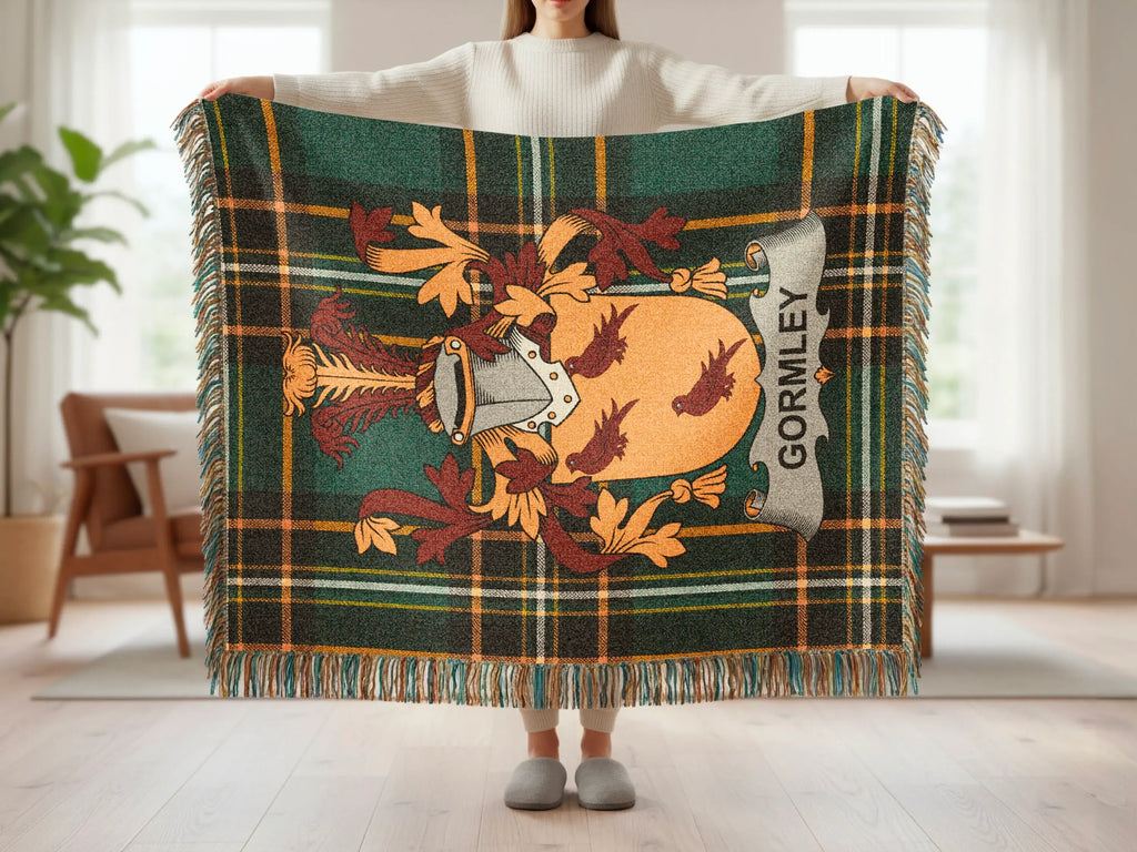 Tartan blanket with Gormley crest and tassels held by a person.