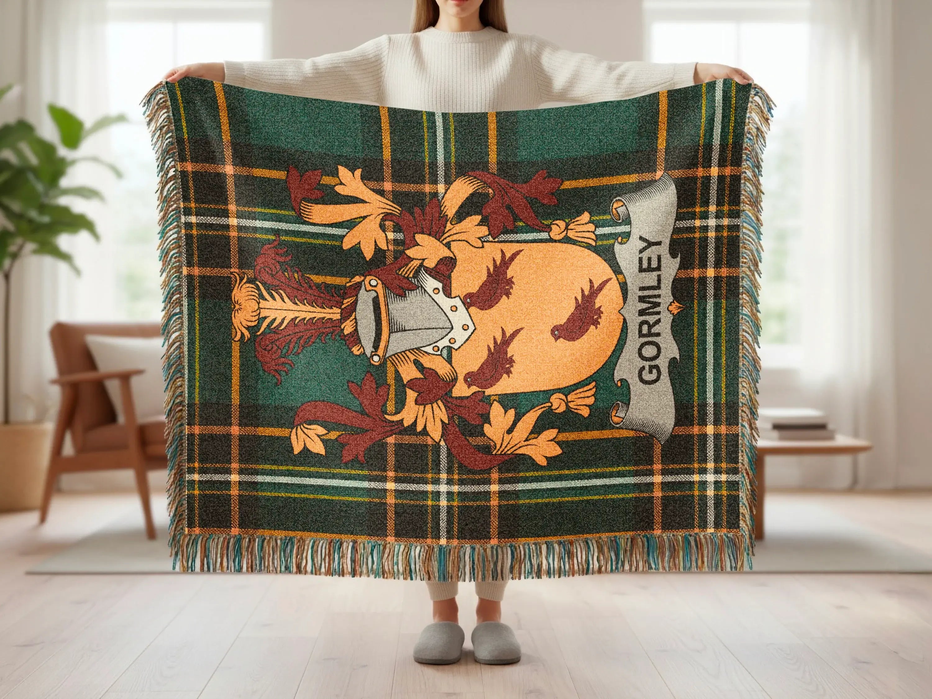 Tartan blanket with Gormley crest and tassels held by a person.