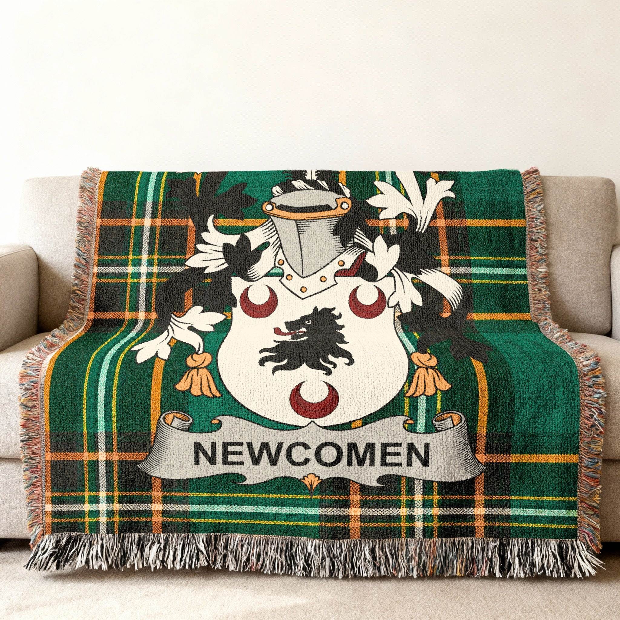 Green tartan blanket with Newcomen family crest draped on a sofa.