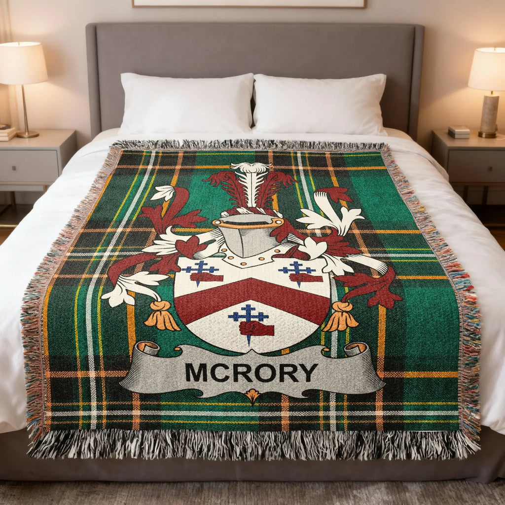 McRory family crest on a green tartan woven blanket on a bed.