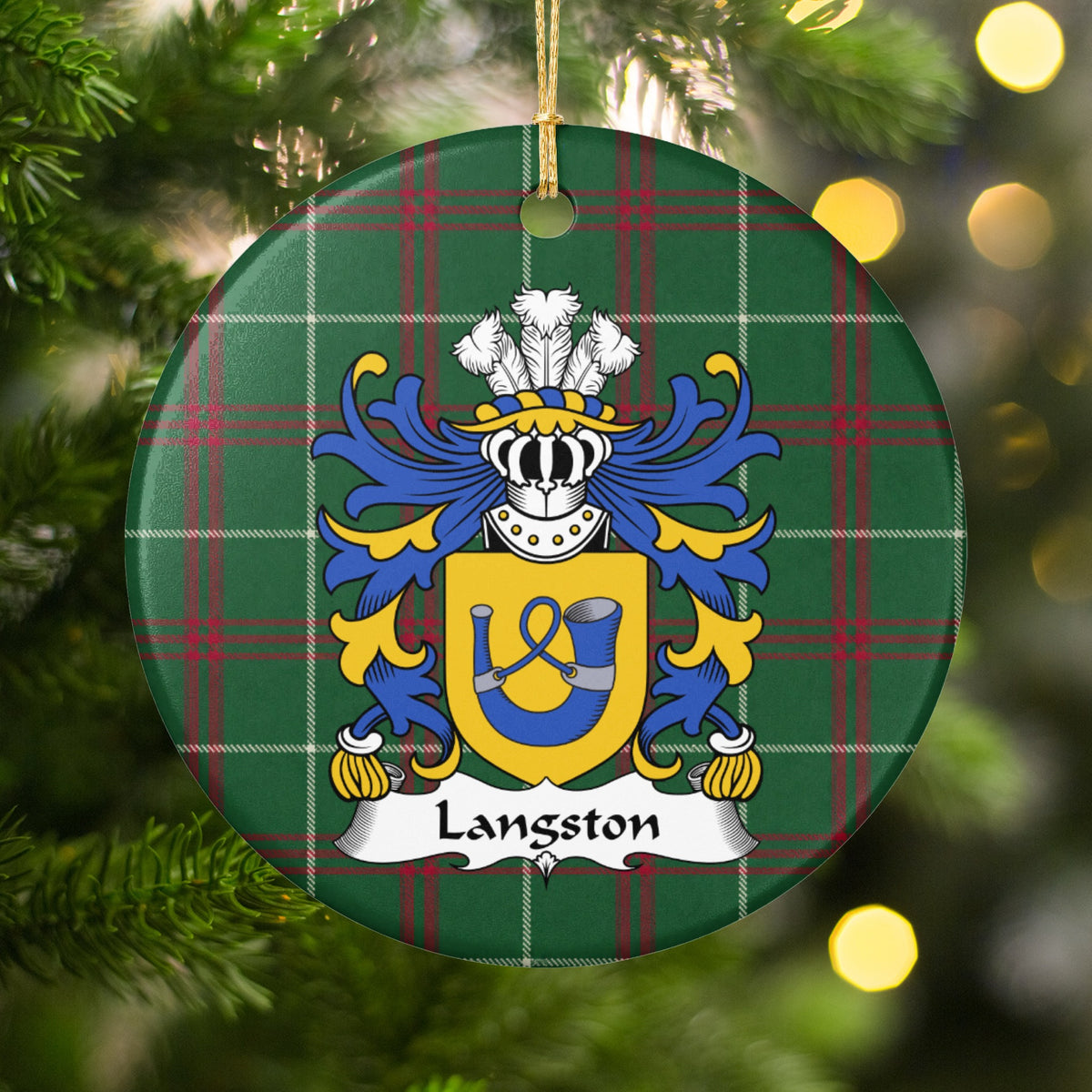Langston ornament hanging on a Christmas tree among green branches and warm lights, with a gold shield with a blue hunting horn and looped cord on Welsh national tartan.
