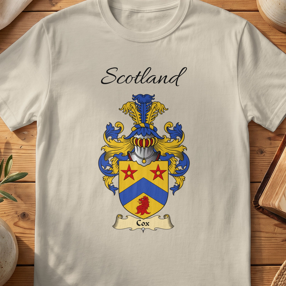 Sand Cox Scottish family shield T-shirt featuring a blue chevron and red stars on gold