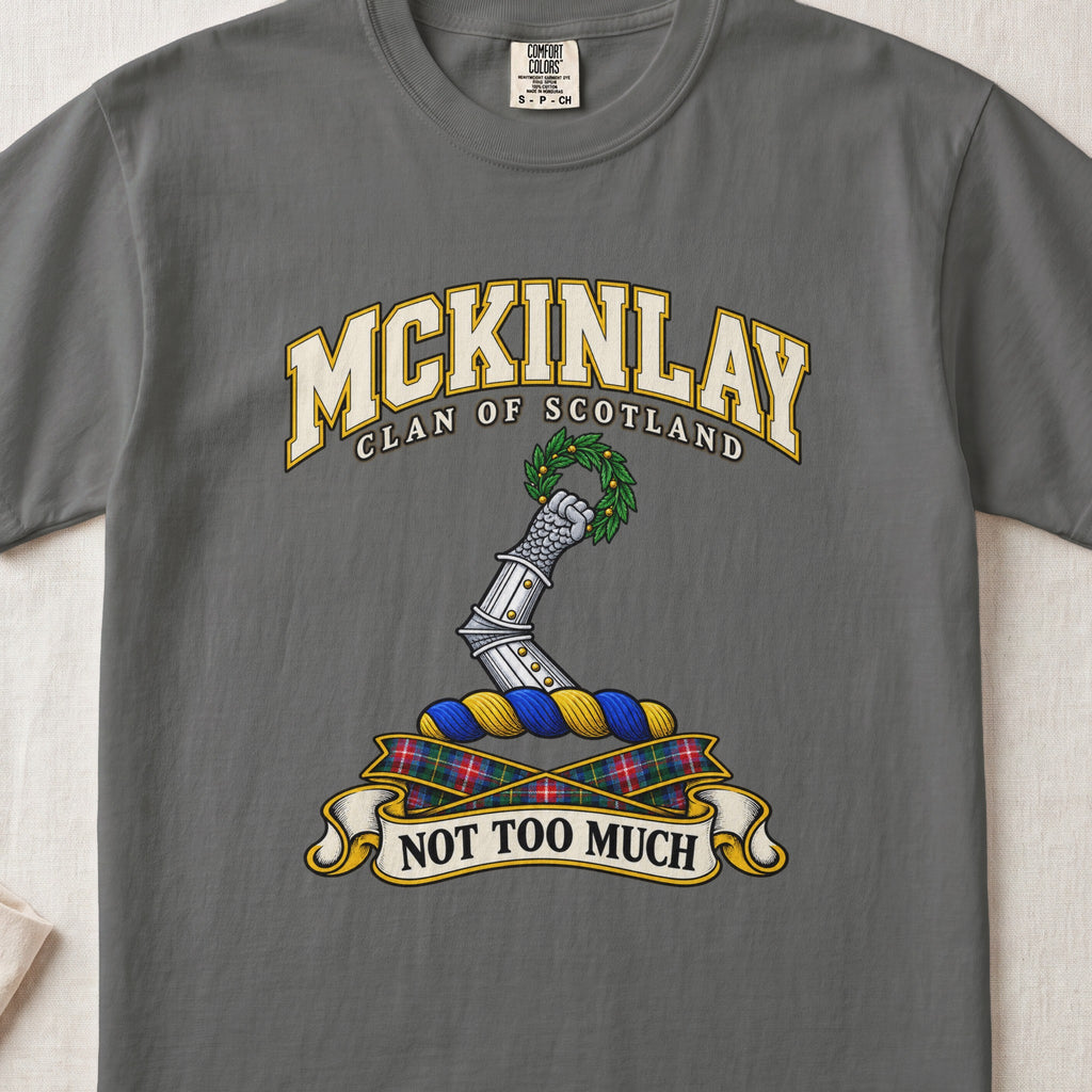 McKinlay Scottish clan T-shirt in Pepper, front view with an armored arm holding a green leafy wreath and motto banner.